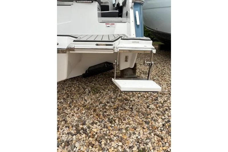 Slide: The Image of 2025 Cobalt R4 Outboard boat with swim platform on gravel surface. - 11