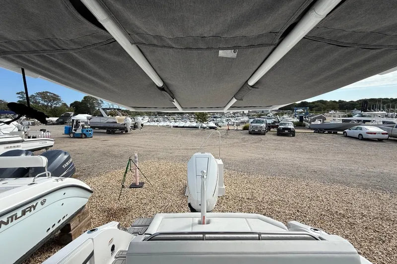 Slide: The Image of 2025 Cobalt R4 Outboard boat in a marina, surrounded by other boats and vehicles. - 12