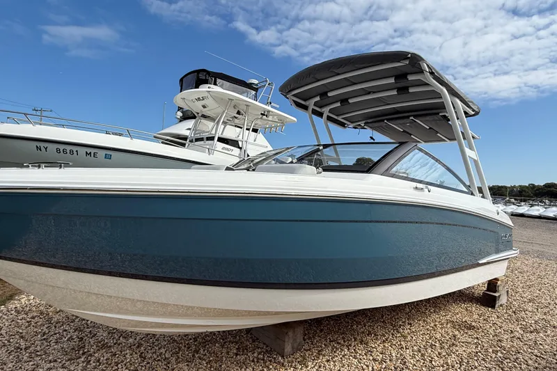 Slide: The Image of 2025 Cobalt R4 Outboard boat on gravel, under a clear blue sky. - 2