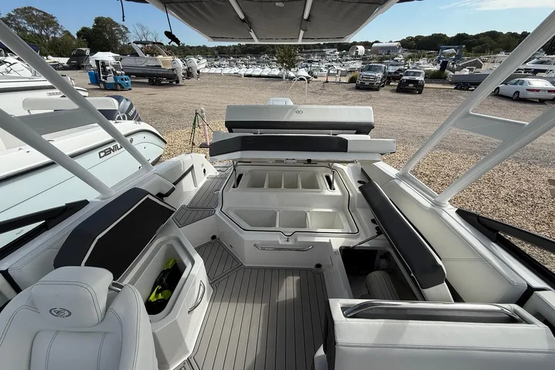 Slide: The Image of 2025 Cobalt R4 Outboard boat interior with seating and storage, displayed at a marina. - 21
