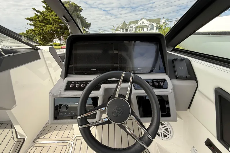 Slide: The Image of 2025 Cobalt R4 Outboard boat dashboard with steering wheel and navigation display. - 33