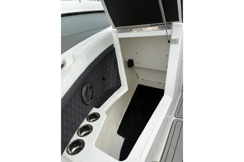 Slide: The Image of 2025 Cobalt R4 Outboard boat interior storage compartment with cup holders and speaker. - 45