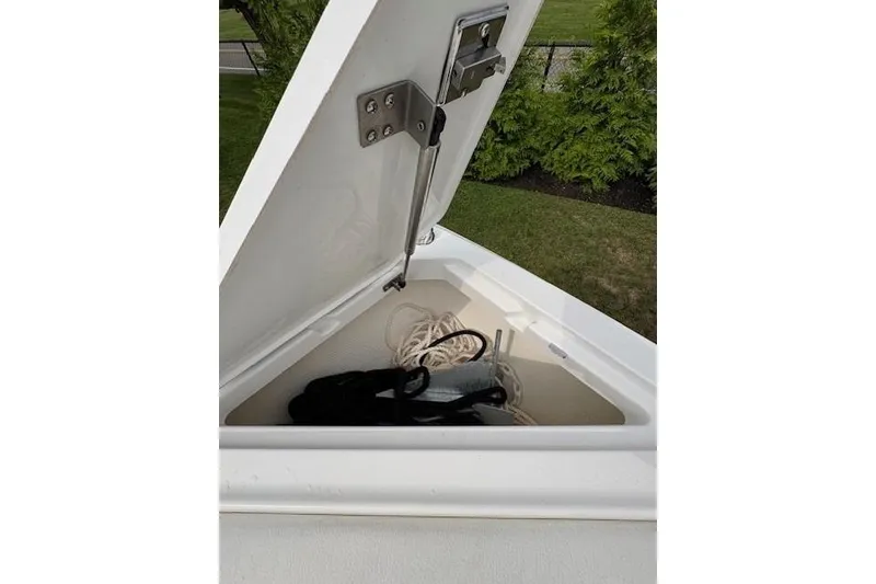 Slide: The Image of Open storage compartment on 2025 Cobalt R4 Outboard boat, containing ropes and anchor. - 47