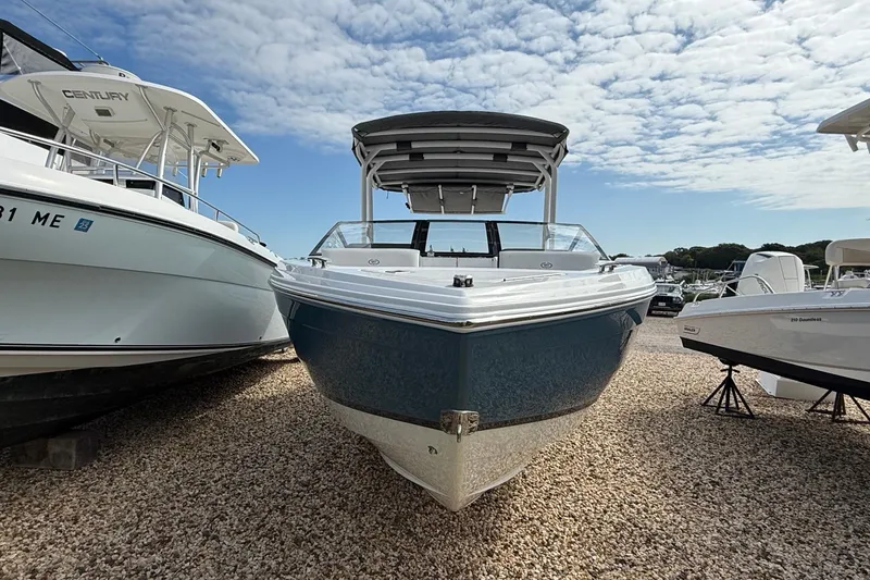Slide: The Image of 2025 Cobalt R4 Outboard boat displayed outdoors under a partly cloudy sky. - 48
