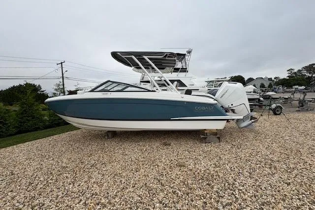 Slide: The Image of 2025 Cobalt R4 Outboard boat on gravel, side view, overcast sky. - 50