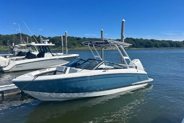 Slide: The Image of 2025 Cobalt R4 Outboard boat docked on a sunny day, with scenic water and trees in the background. - 52