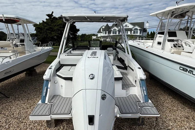 Slide: The Image of 2025 Cobalt R4 Outboard boat displayed on gravel lot, surrounded by other boats. - 9