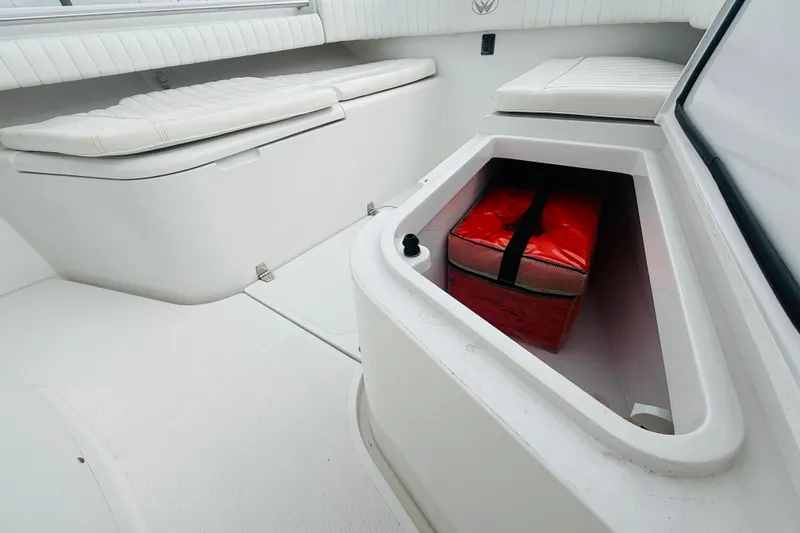 Slide: The Image of 2009 Southport 26 Center Console boat interior with storage compartment and red bag. - 14