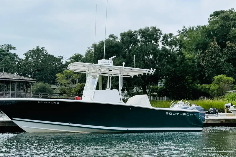 Slide: The Image of 2009 Southport 26 Center Console boat docked by lush greenery. - 2