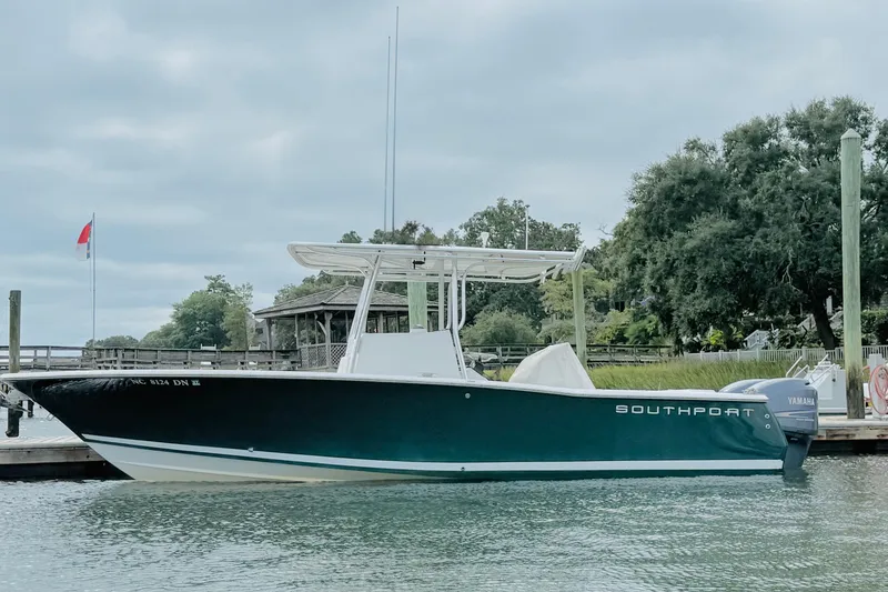Slide: The Image of 2009 Southport 26 Center Console boat docked by lush greenery. - 7