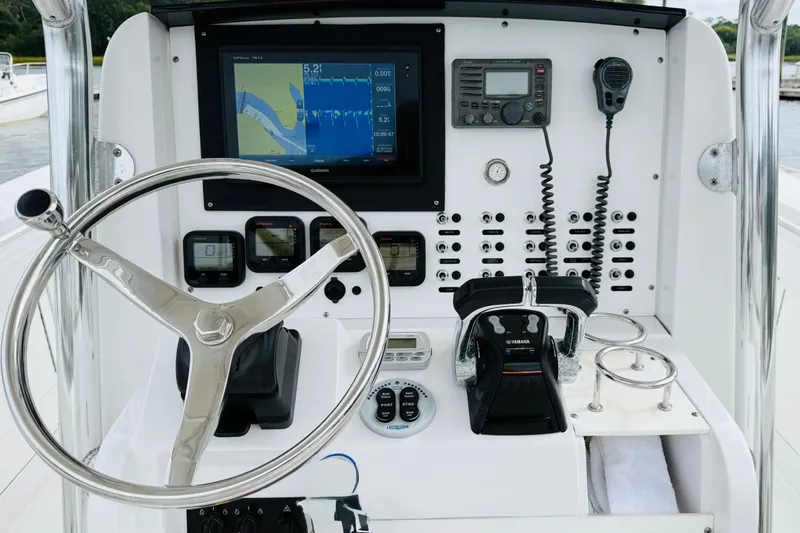 Slide: The Image of 2009 Southport 26 Center Console boat dashboard with steering wheel, navigation, and communication equipment. - 8