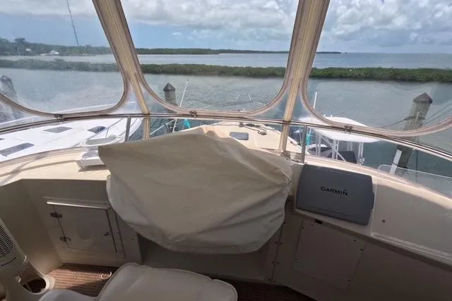 Slide: The Image of 1987 Californian 45 Motor Yacht helm with covered controls, overlooking serene marina view. - 16