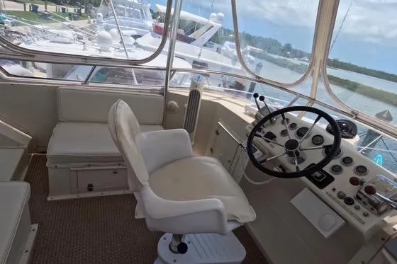 Slide: The Image of 1987 Californian 45 Motor Yacht helm with steering wheel and captain's chair, docked at marina. - 19