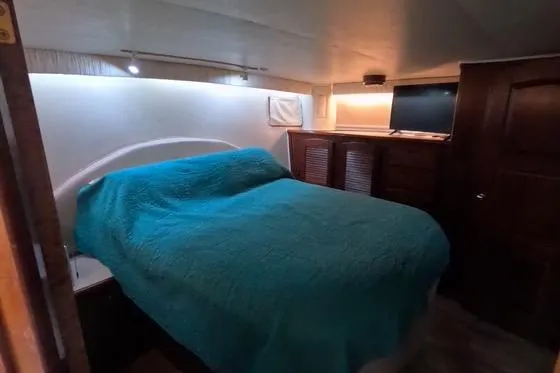 Slide: The Image of 1987 Californian 45 Motor Yacht bedroom with teal bedding and TV. - 45