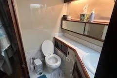 Slide: The Image of 1987 Californian 45 Motor Yacht bathroom with toilet, sink, and storage cabinets. - 59