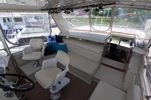 Slide: The Image of 1987 Californian 45 Motor Yacht interior with seating and helm, featuring white chairs and cushions. - 8