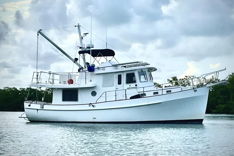 The Image of 1999 Kadey-Krogen 39 yacht on calm water under cloudy sky. - 0