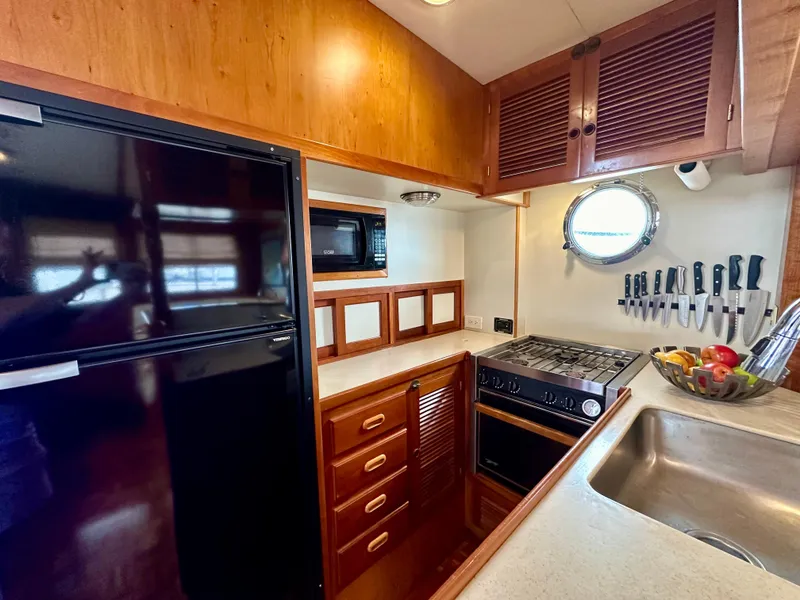 Slide: The Image of Interior of 1999 Kadey-Krogen 39 yacht with wooden cabinetry and black refrigerator. - 11