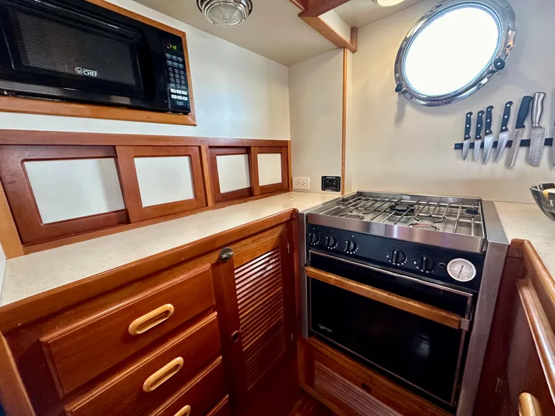 Slide: The Image of Interior of 1999 Kadey-Krogen 39 boat with striped seating and wooden helm. - 12