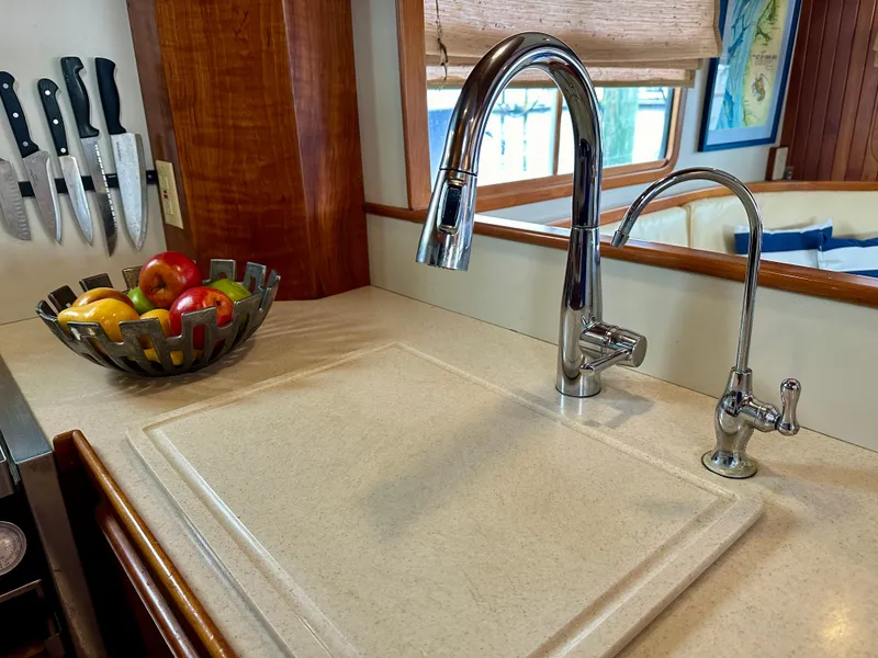 Slide: The Image of 1999 Kadey-Krogen 39 yacht interior with wooden helm, striped seating, and navigation equipment. - 13