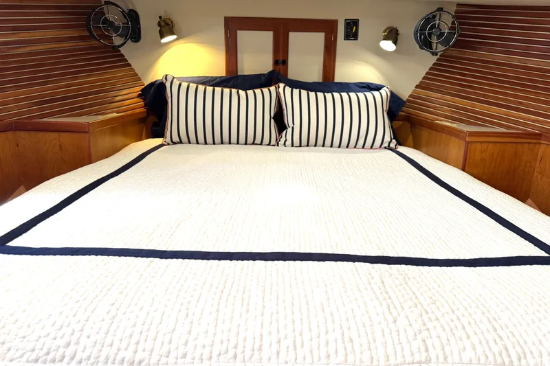 Slide: The Image of Cozy bedroom in 1999 Kadey-Krogen 39 yacht with wood paneling and striped bedding. - 27