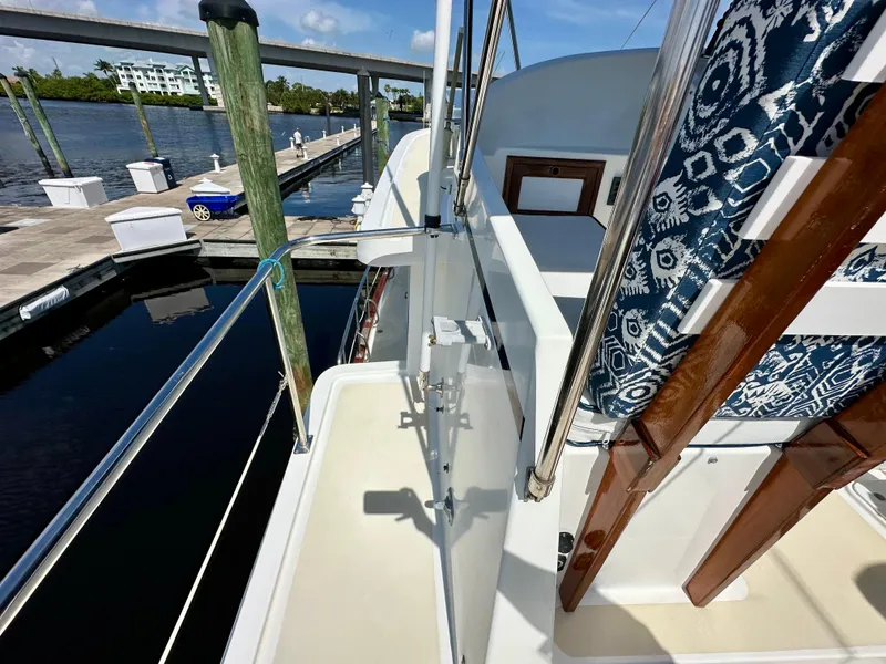 Slide: The Image of 1999 Kadey-Krogen 39 yacht deck with seating, wooden door, and window. - 39