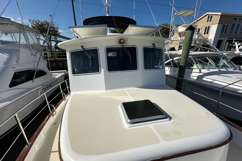 Slide: The Image of 1999 Kadey-Krogen 39 yacht deck with covered equipment and marina view. - 45