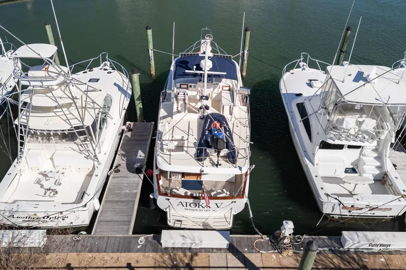 Slide: The Image of Three boats docked at a marina, featuring a 1999 Kadey-Krogen 39 in the center. - 54