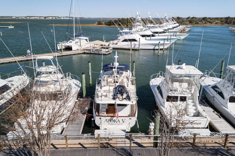 Slide: The Image of Boats docked at a marina, featuring a 1999 Kadey-Krogen 39 in the center. - 55