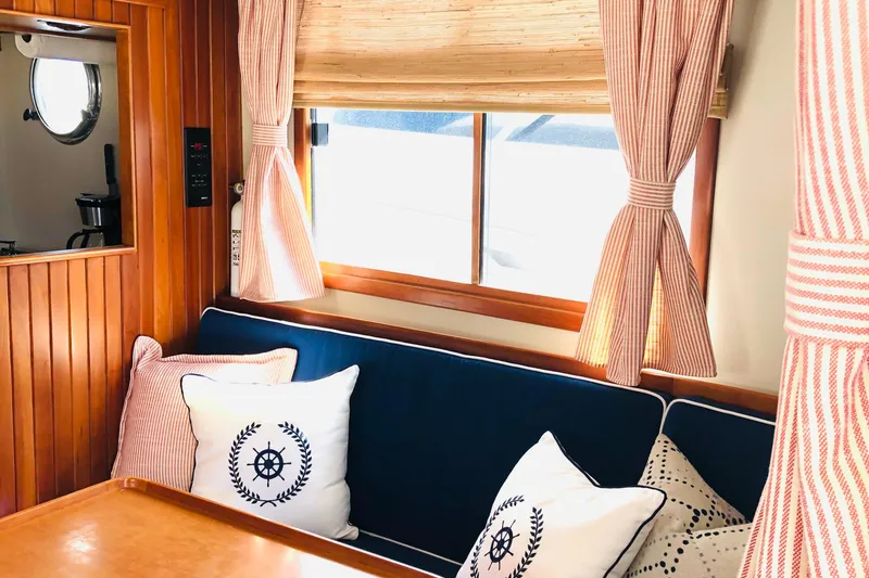 Slide: The Image of Interior of 1999 Kadey-Krogen 39 yacht with blue seating, wooden table, and decorative flowers. - 6