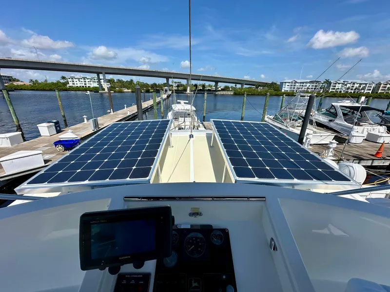 Slide: The Image of 1999 Kadey-Krogen 39 yacht deck with seating, American flag, and marina view. - 36