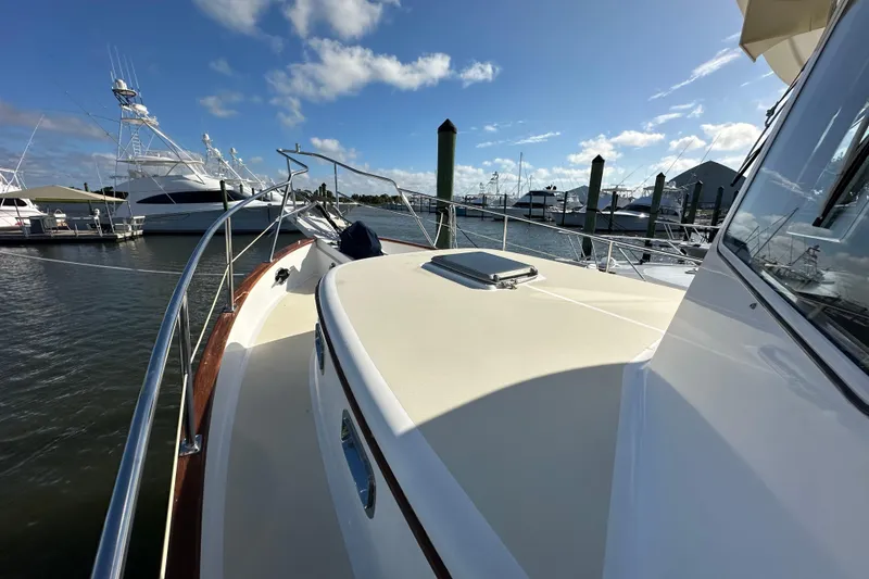 Slide: The Image of 1999 Kadey-Krogen 39 yacht cockpit with blue canopy and steering wheel, docked at marina. - 42