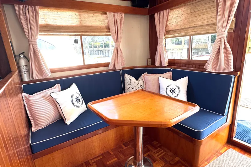Slide: The Image of Cozy interior of 1999 Kadey-Krogen 39 yacht with blue seating and floral centerpiece. - 5