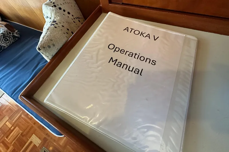 Slide: The Image of Operations manual for Kadey-Krogen 39, 1999, on a wooden table. - 57