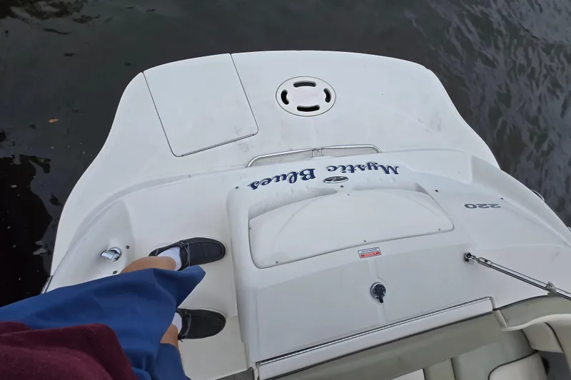 Slide: The Image of 2005 Sea Ray 220 Sundeck boat stern view with person standing on deck. - 15