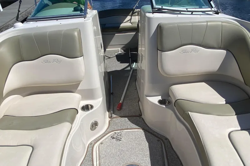 Slide: The Image of 2005 Sea Ray 220 Sundeck interior with cushioned seating and cup holders. - 19