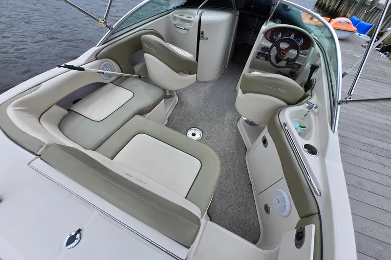 Slide: The Image of 2005 Sea Ray 220 Sundeck interior with seating and steering wheel, dockside view. - 3