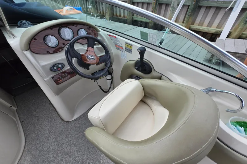 Slide: The Image of 2005 Sea Ray 220 Sundeck helm with steering wheel and gauges. - 4