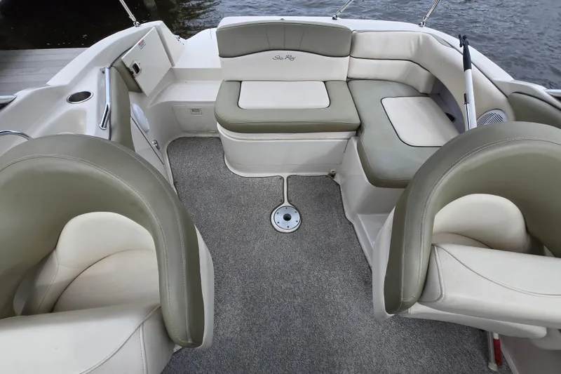 Slide: The Image of 2005 Sea Ray 220 Sundeck interior with cushioned seating and carpeted floor. - 8