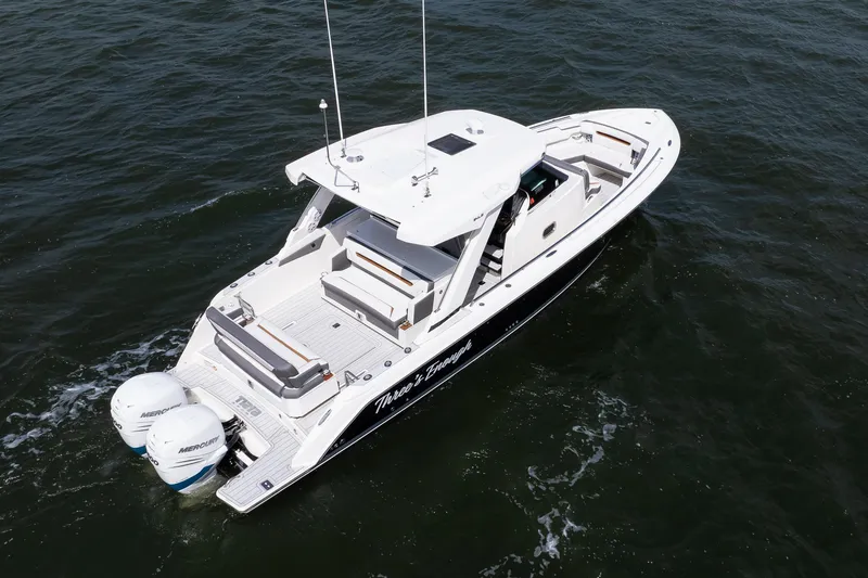 Slide: The Image of 2020 Tiara Sport 34 LS boat cruising on open water, featuring dual Mercury engines. - 12