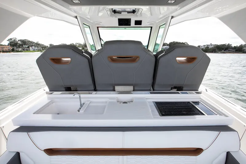 Slide: The Image of 2020 Tiara Sport 34 LS boat interior with seating, sink, and grill on water. - 15