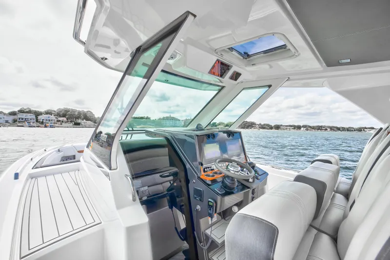 Slide: The Image of 2020 Tiara Sport 34 LS boat interior with helm, steering wheel, and navigation screens. - 16
