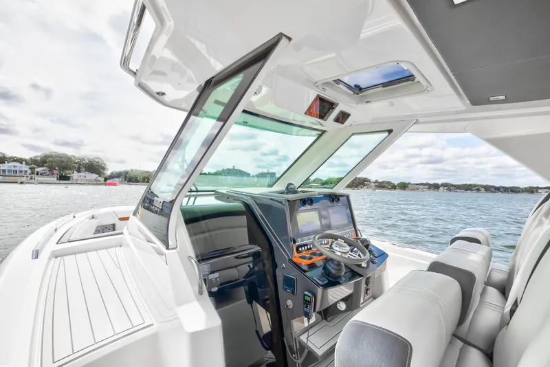 Slide: The Image of 2020 Tiara Sport 34 LS boat interior with helm, steering wheel, and navigation screens. - 18