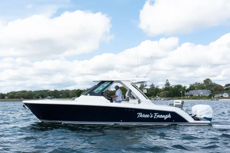 Slide: The Image of 2020 Tiara Sport 34 LS boat on water, side view, with scenic background. - 3