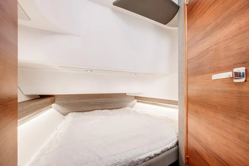 Slide: The Image of 2020 Tiara Sport 34 LS cabin interior with cozy bed and wooden accents. - 30