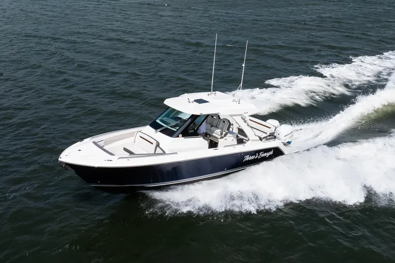 Slide: The Image of 2020 Tiara Sport 34 LS boat cruising on open water, creating a dynamic wake. - 7