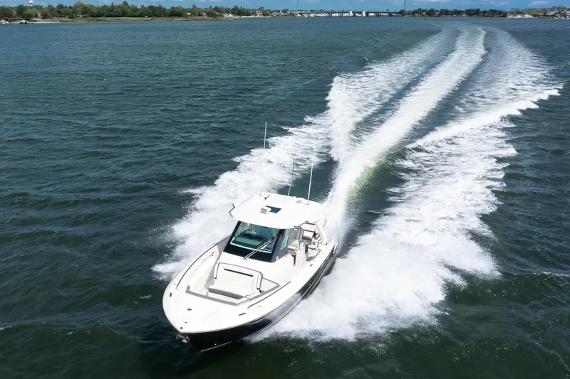 Slide: The Image of 2020 Tiara Sport 34 LS boat cruising on open water, leaving a wake trail. - 8