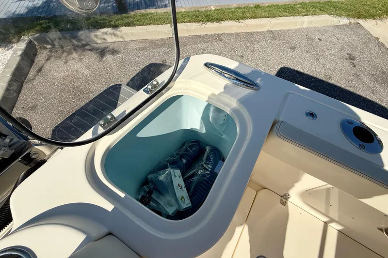 Slide: The Image of Storage compartment on 2026 Scout 260 LXF boat, featuring built-in cooler and accessories. - 11