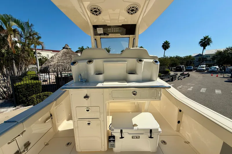 Slide: The Image of 2026 Scout 260 LXF boat interior with storage and Yeti cooler, sunny day. - 12
