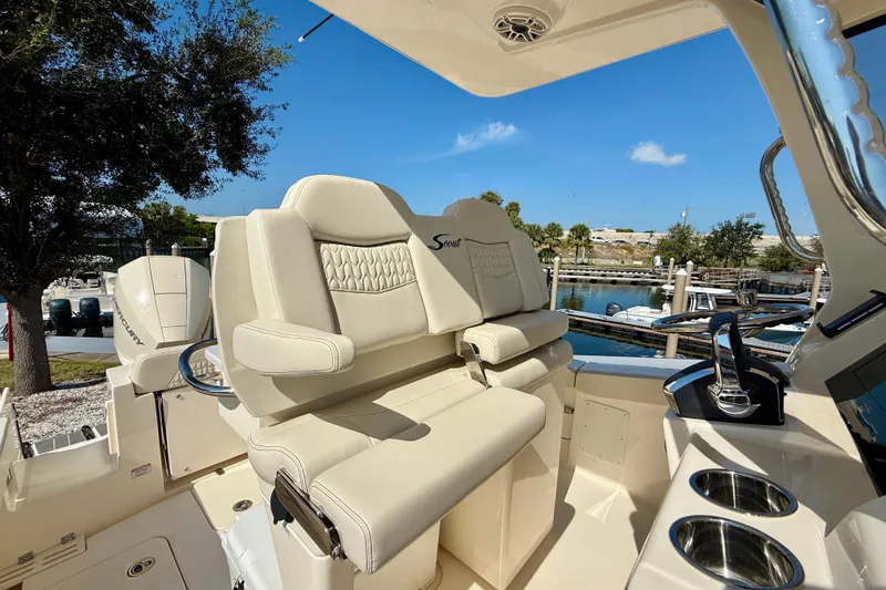 Slide: The Image of Luxurious seating on 2026 Scout 260 LXF boat, docked by a scenic marina. - 16